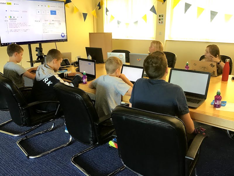Children learning Python at a Summer of Code event